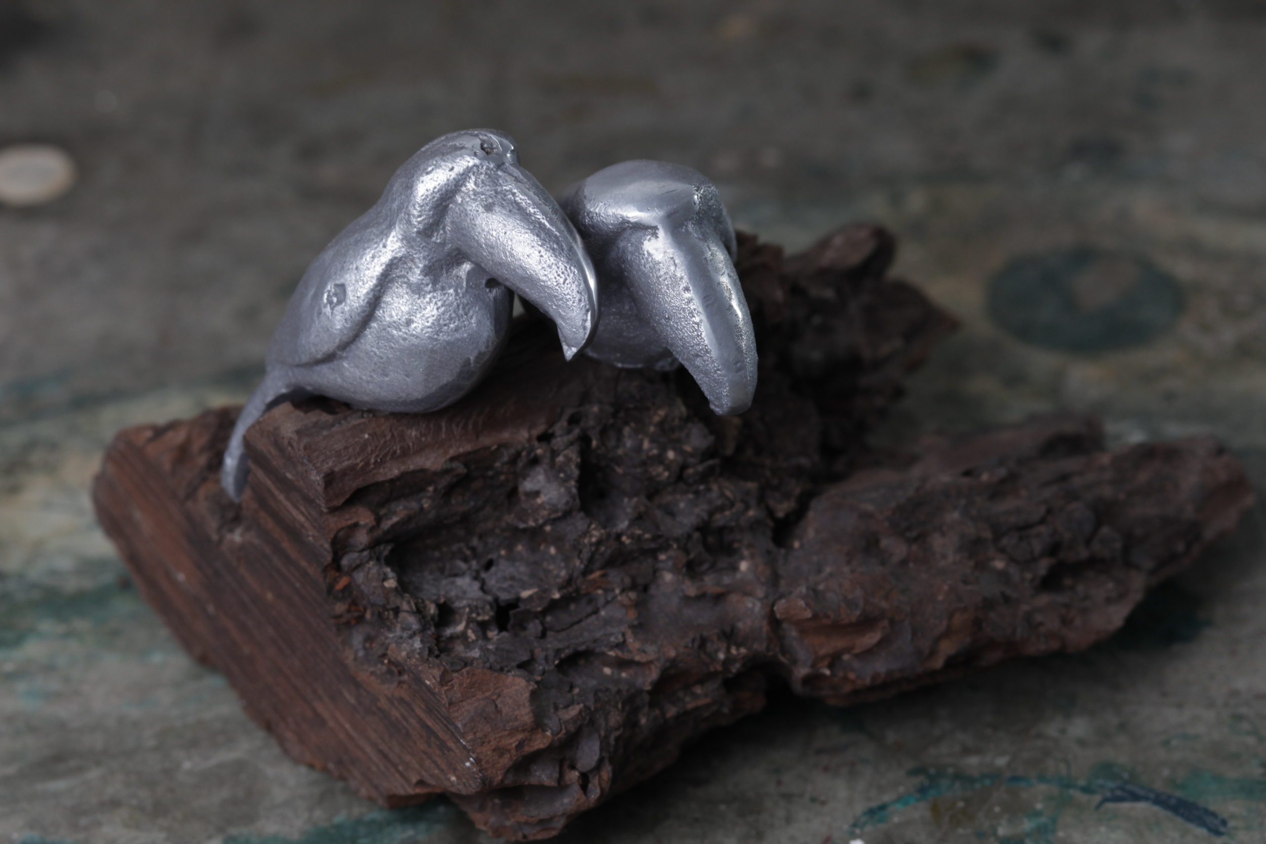 tucanes de aluminio sobre tronco de quebracho natural.
